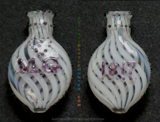 A tiny colorless round flattened smelling bottle with white ribbons and applied green and amethyst beads. --- AntiqueBottleHunter.com
