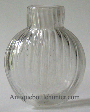 An early colorless pattern-molded smelling bottle or scent in a round or flattened globular form, with pontil mark. Height, 2 - 1/4 in. Width, 1 - 3/4 in. --- AntiqueBottleHunter.com