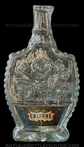 A very light aquamarine 'Floral Spray' complete with a hard-to-find label. (4 - 3/8 in. tall) --- AntiqueBottleHunter.com