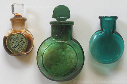Three examples of other forms of salts. The first is a colorless bottle with a stopper and label that reads: Refreshing, No. 4711, Reg. U.S. Pat. Off., MIGNON SALTS, Made in U.S.A. The next is yellow green with a stopper and contents inside. There is a destroyed partial label on the other side. The far right is a bulbous teal bottle, that was probably used for some sort of salts or scent. It has a ground throat to accept a stopper. --- AntiqueBottleHunter.com