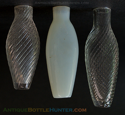 A firey opalescent scent bottle with traces of gold leaf patterns and 'Forget Me Not' on the other side... flanked by a couple of colorless pattern molded smelling bottles --- AntiqueBottleHunter.com